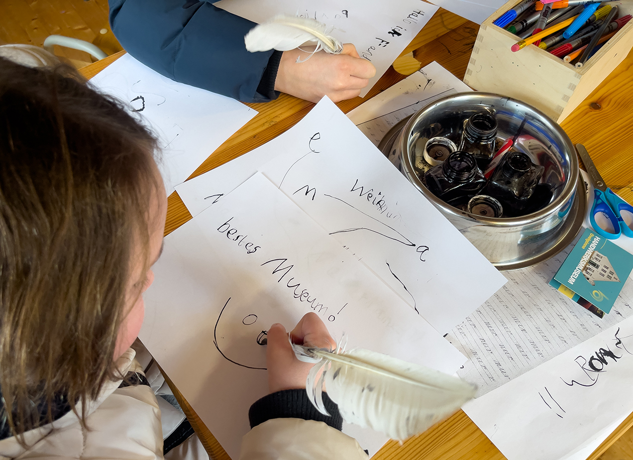 Kinder beim gemeinsamen Werkzeug-Erkunden im Museum